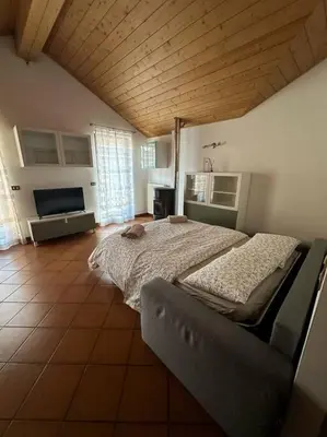 a bedroom with a large bed with a wooden ceiling at Suan Hut in Ziano di Fiemme