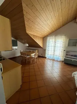 a kitchen and dining room with a table and chairs at Suan Hut in Ziano di Fiemme