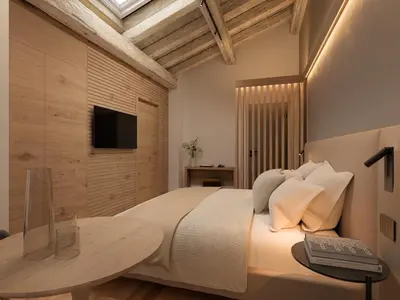 a bedroom with a bed with a table and a television at Naturae Lodge Wellness & Spa in Alleghe