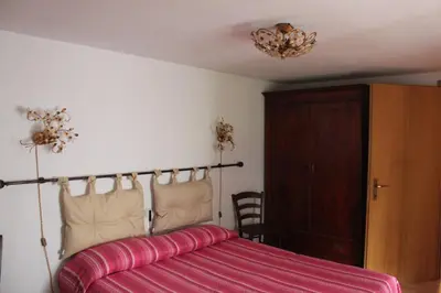 a bedroom with a bed and a wooden cabinet at Casa Sirena in Canale dʼAgordo