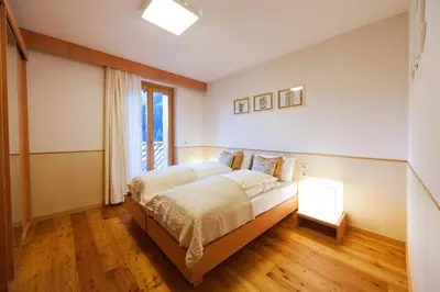 a bedroom with a bed and a desk with a chair at Lumen in Falcade