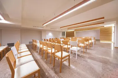 a room with chairs and a podium in a room with wooden ceilings at Lumen in Falcade