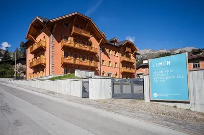 a building with a sign in front of it at Lumen in Falcade