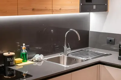 a kitchen sink with a faucet on a counter at Dolomiti Luxury Mountain View SKI-IN SKI-OUT in Canazei
