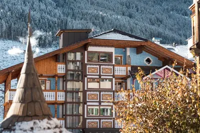 a building in the snow with a mountain at Dolomiti Luxury Mountain View SKI-IN SKI-OUT in Canazei