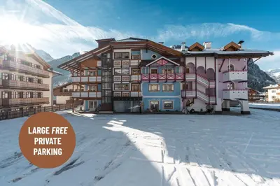 a large building in the middle of a snow covered yard at Dolomiti Luxury Mountain View SKI-IN SKI-OUT in Canazei