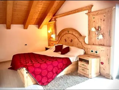 a bedroom with a large bed with a red blanket at Bella Vista in Canale San Bovo