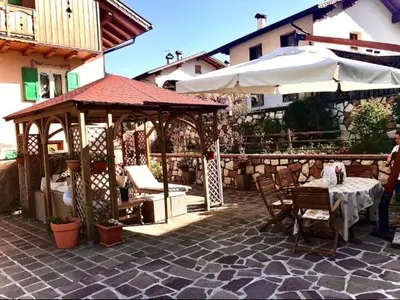 a patio with a gazebo and a table and umbrella at Bella Vista in Canale San Bovo