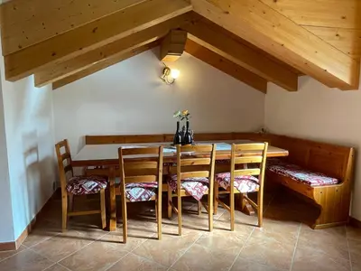 a dining room with a wooden table and chairs at Bella Vista in Canale San Bovo