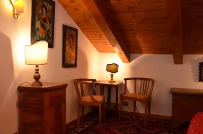 a room with a table and two chairs and a lamp at Mansarda a Cortina in Cortina dʼAmpezzo