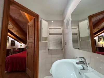 a bathroom with a sink and a mirror at Mansarda a Cortina in Cortina dʼAmpezzo