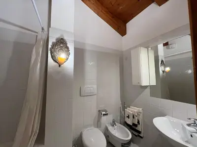 a white bathroom with a sink and a toilet at Mansarda a Cortina in Cortina dʼAmpezzo