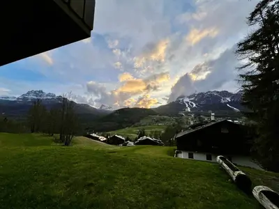 a view of a field with mountains in the background at Mansarda a Cortina in Cortina dʼAmpezzo