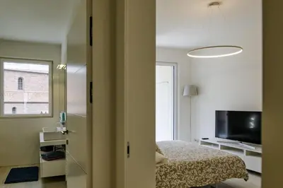 a bedroom with a bed and a large window at SWEETHOME MUSEO - con Garage in Bolzano
