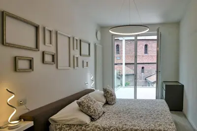 a white room with a bed and a tv at SWEETHOME MUSEO - con Garage in Bolzano