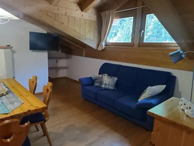 a living room with a blue couch and a table at Appartamento Diobono in San Lugano