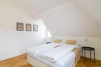 a white bedroom with a bed with white sheets at Villa Bregenz Apartment in Merano