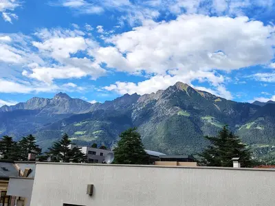 a view of a mountain range with clouds in the sky at Villa Bregenz Apartment in Merano