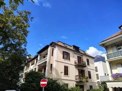 a white building with a stop sign in front of it at Villa Bregenz Apartment in Merano