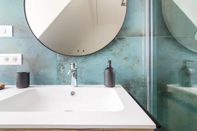 a bathroom with a white sink and a mirror at Villa Bregenz Apartment in Merano