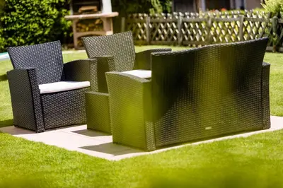 a group of chairs sitting in the grass at Appartamenti Hetty in Santa Cristina in Val Gardena
