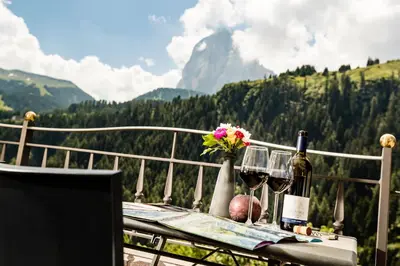 a table with wine glasses and a vase of flowers at Appartamenti Hetty in Santa Cristina in Val Gardena