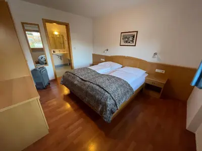 a bedroom with a bed and a wooden floor at Appartamenti Hetty in Santa Cristina in Val Gardena