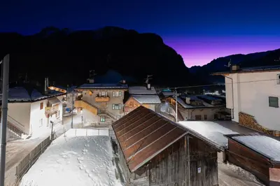 a view of a town in the snow at night at Cesa alla Cascata in Canazei