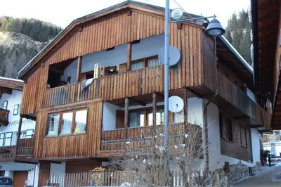 a wooden building with a lot of windows at Cesa alla Cascata in Canazei