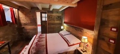 a bedroom with a bed in a wooden cabin at Chalet Pra Dell OSTIO Primiero San Martino di Castrozza in Fiera di Primiero