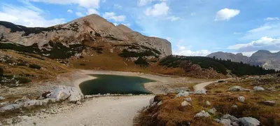 a mountain with a lake on the side of it at Appartamenti Codàn in San Vito di Cadore