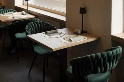 a restaurant with green chairs and a table and a window at Sole Boutique Hotel in Vipiteno