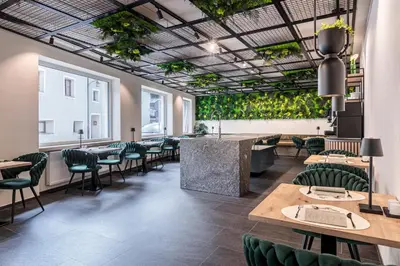 a restaurant with tables and chairs and plants on the ceilings at Sole Boutique Hotel in Vipiteno