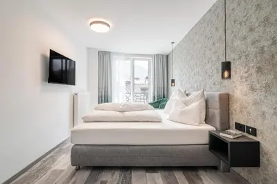 a bedroom with a large white bed and a window at Sole Boutique Hotel in Vipiteno