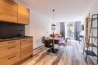 a kitchen and dining room with a table and chairs at Sole Boutique Hotel in Vipiteno