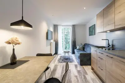 a kitchen and living room with a blue couch at Sole Boutique Hotel in Vipiteno
