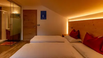 a bedroom with two beds with red pillows at Villa Hilde in San Cassiano