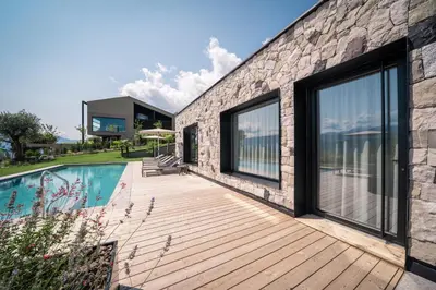 a house with a wooden deck next to a swimming pool at View - AgriSuites in Caldaro