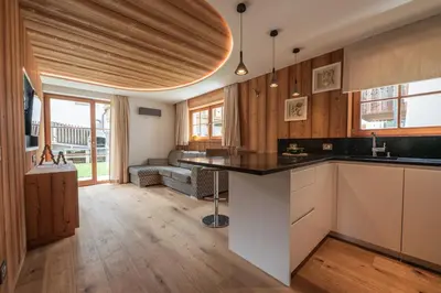 a kitchen with a counter and a living room at Mountainlodge Luxalpine in San Vigilio Di Marebbe