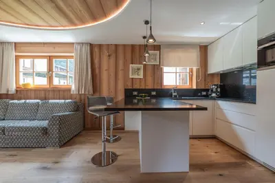 a kitchen with a table and a couch in a room at Mountainlodge Luxalpine in San Vigilio Di Marebbe