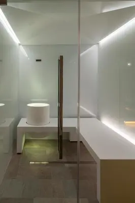 a white bathroom with a bench and a sink at Mountainlodge Luxalpine in San Vigilio Di Marebbe