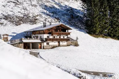 a large wooden house in the snow with a road at Grossgasteigerhof in Selva dei Molini