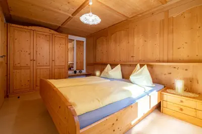 a bedroom with a bed in a wooden room at Grossgasteigerhof in Selva dei Molini
