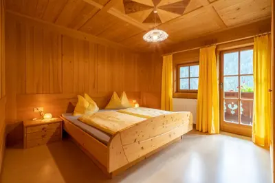 a wooden bed in a room with a window at Grossgasteigerhof in Selva dei Molini