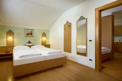 a bedroom with a bed and a large mirror at Residence Ciasa Morin in Corvara in Badia