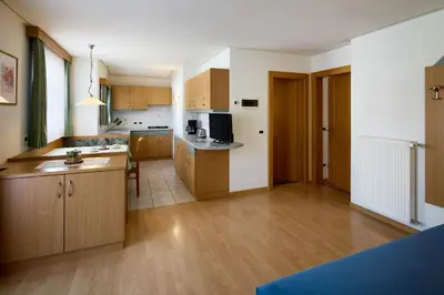 a large kitchen with wooden cabinets and a kitchen island at Residence Ciasa Morin in Corvara in Badia