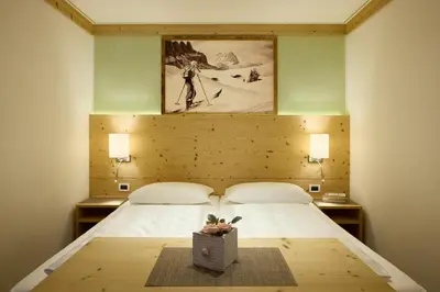 a bedroom with two beds and a picture on the wall at Residence Ciasa Morin in Corvara in Badia