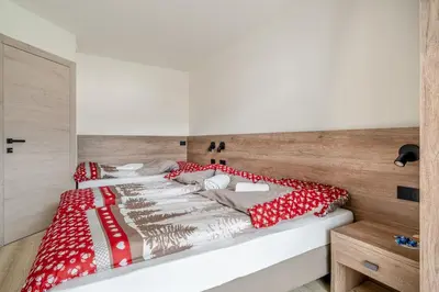 two beds in a room with red and white pillows at Prà Lisandro in Cavalese
