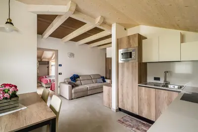 a kitchen and a living room with a couch at Prà Lisandro in Cavalese