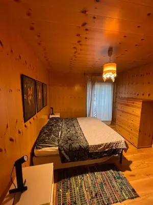 a bedroom with a bed in a wooden room at Pragma Apartments - Appartamento Arcade in Predazzo